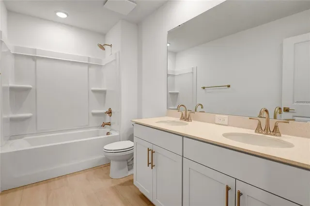 a bathroom with a double vanity sink toilet mirror and shower