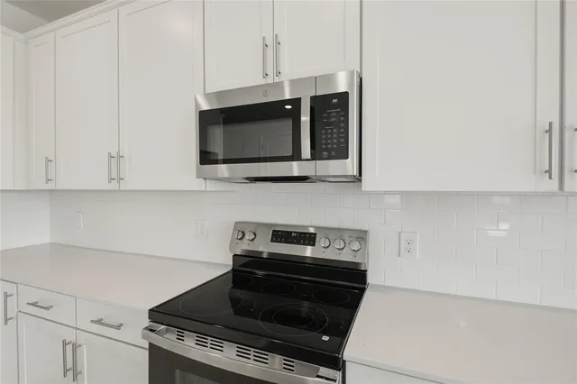 a kitchen with stainless steel appliances a stove a microwave and cabinets