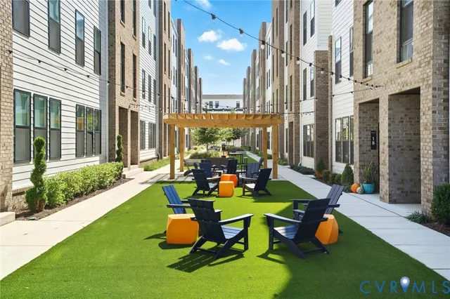 a view of a patio with chairs and floor to ceiling window in backyard