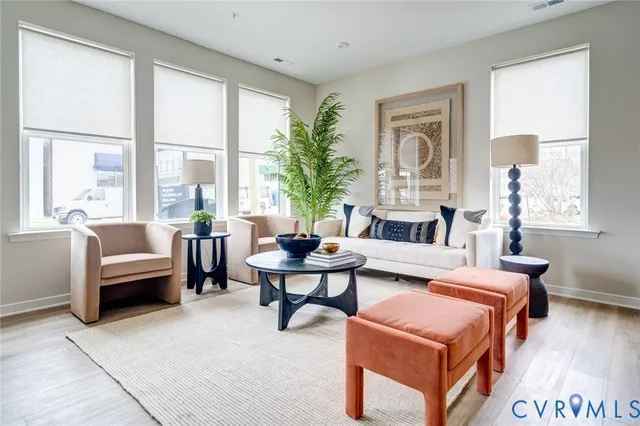 a living room with furniture and a potted plant next to a window