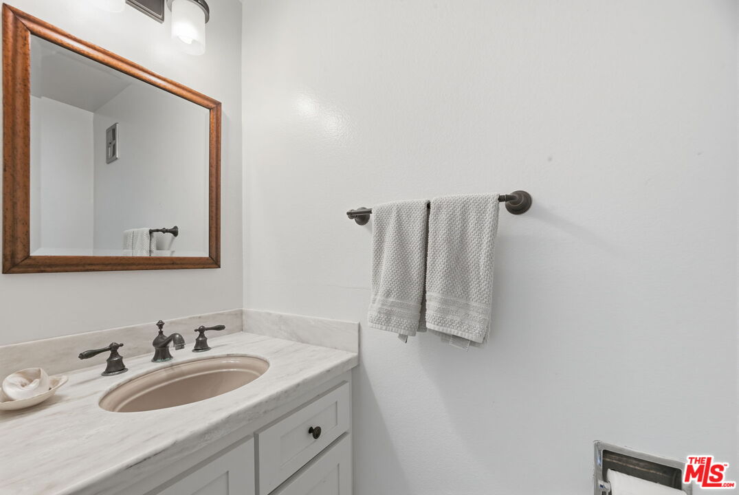 28370 Rey De Copas Lane Malibu, CA 90265 - Photo 11 of 33 a bathroom with a granite countertop sink and a mirror