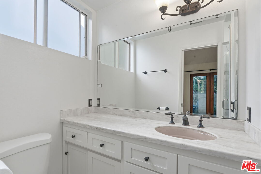 28370 Rey De Copas Lane Malibu, CA 90265 - Photo 22 of 33 a bathroom with a granite countertop sink and a mirror