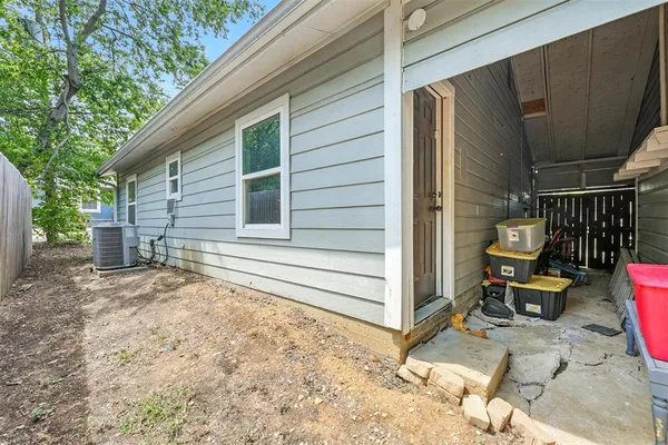a backyard of a house with chairs and wooden fence