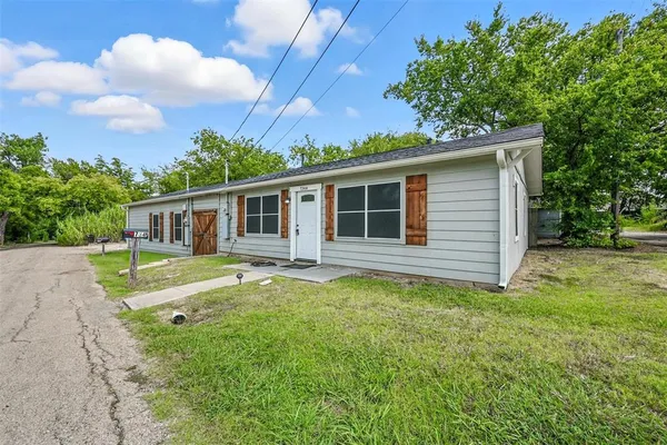 a view of a house with backyard and sitting area