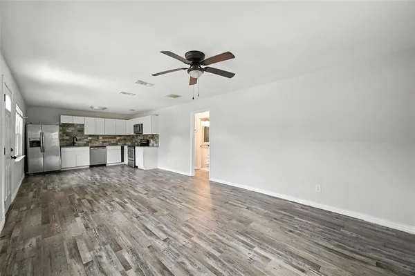a view of a kitchen with wooden floor and a ceiling fan