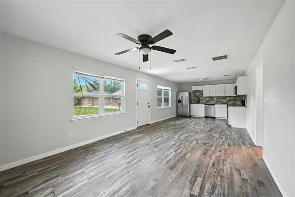 a view of a kitchen with wooden floor and a ceiling fan