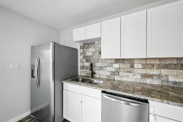 a kitchen with stainless steel appliances granite countertop a refrigerator and a sink