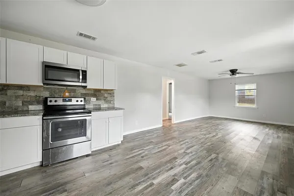 a kitchen with granite countertop a stove and a microwave