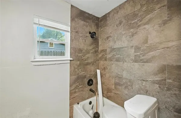 a bathroom with a toilet and a shower