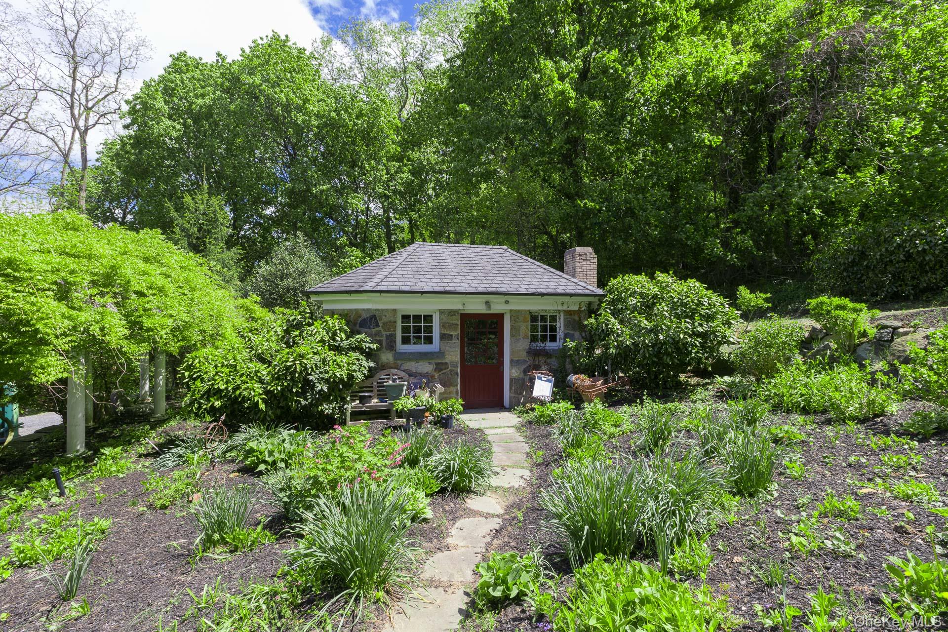 4 Horse Hollow Road Locust Valley, NY 11560 - Photo 46 of 48 a table and chairs under an umbrella in a garden