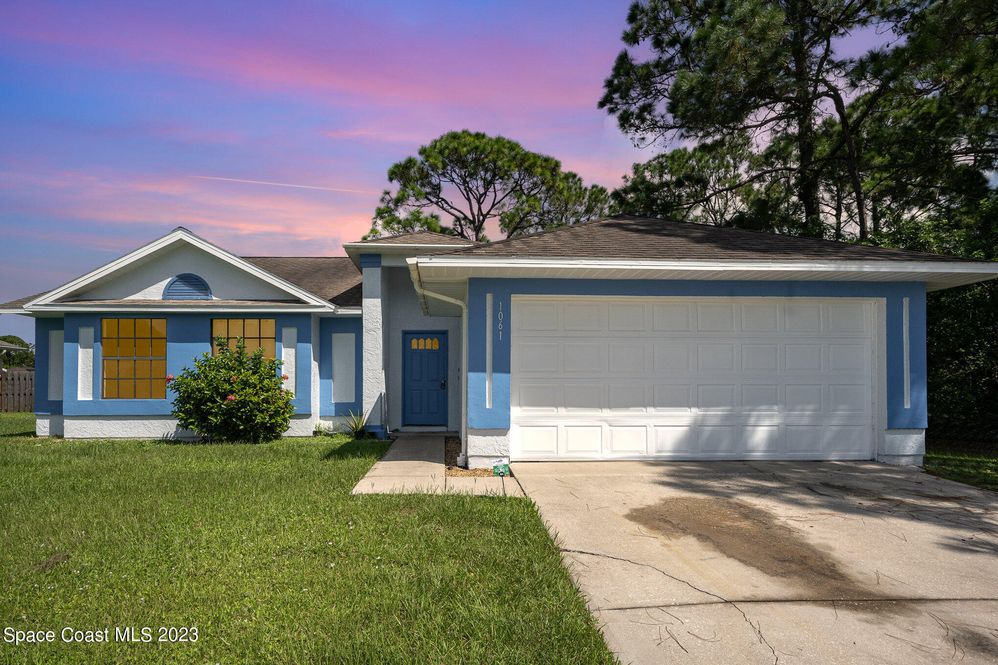 1061 Spring Street Northwest Palm Bay, FL 32907 - Photo 2 of 23 a front view of a house with a yard and garage