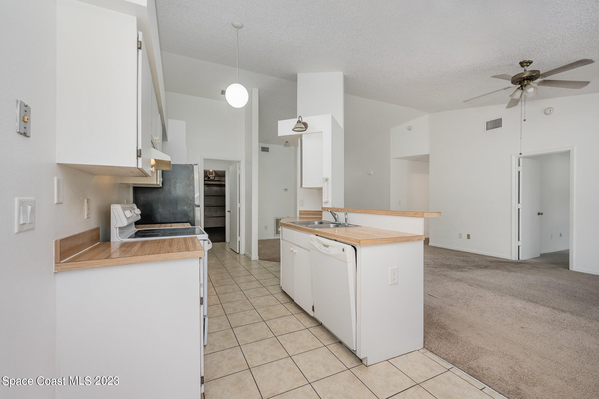1061 Spring Street Northwest Palm Bay, FL 32907 - Photo 9 of 23 a kitchen with a stove a sink and a refrigerator