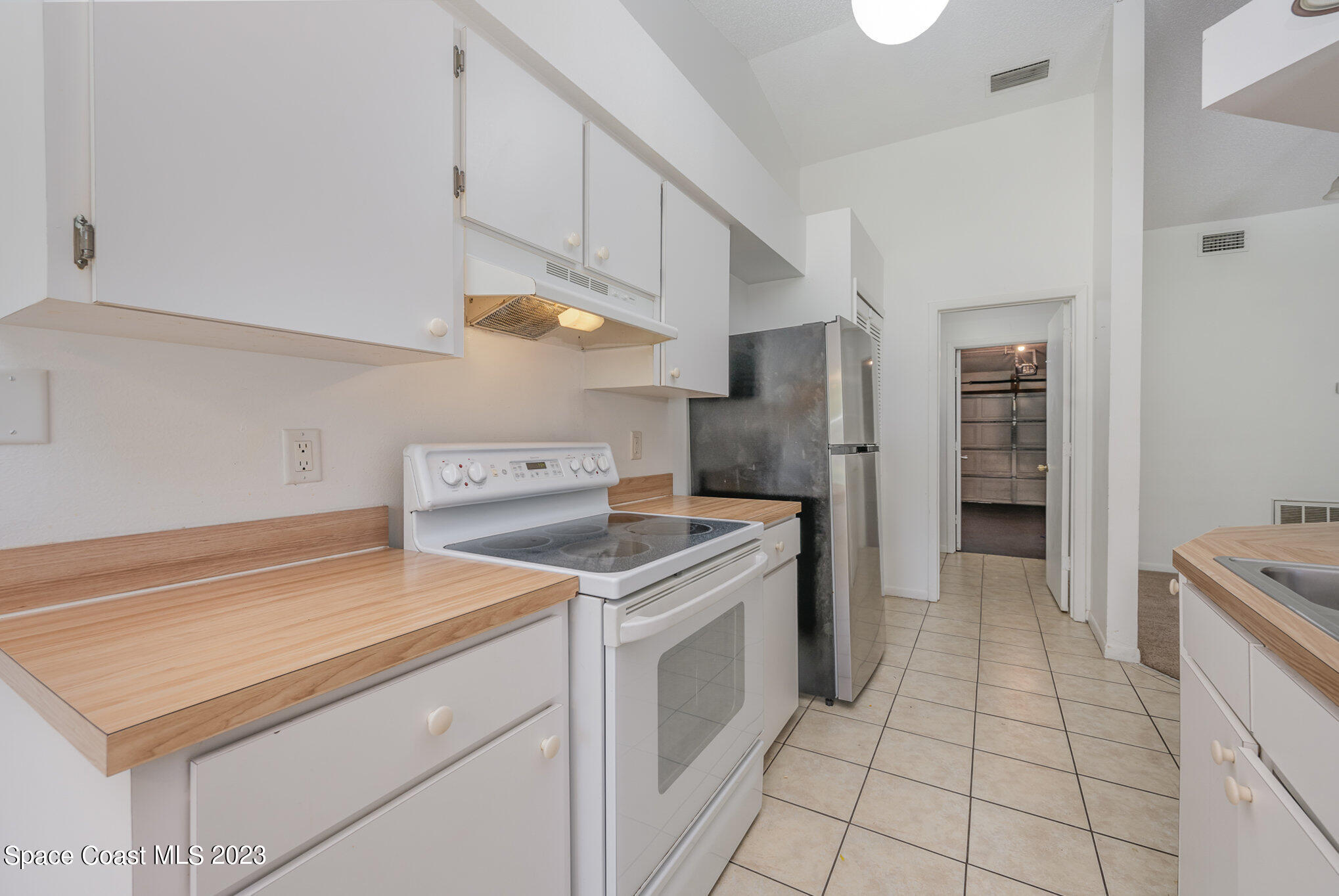1061 Spring Street Northwest Palm Bay, FL 32907 - Photo 10 of 23 a kitchen with a stove cabinets and refrigerator