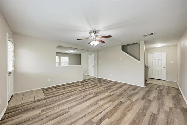 a view of a livingroom with a ceiling fan window and wooden floor