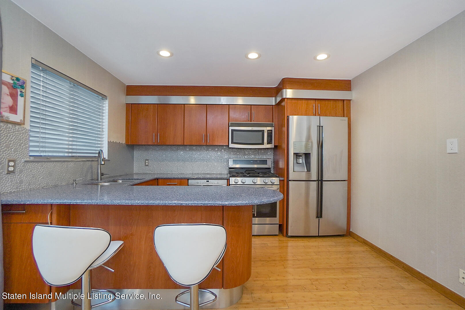 114 Commodore Drive Staten Island, NY 10309 - Photo 12 of 31 a kitchen with stainless steel appliances granite countertop a sink a stove a refrigerator cabinets and chairs