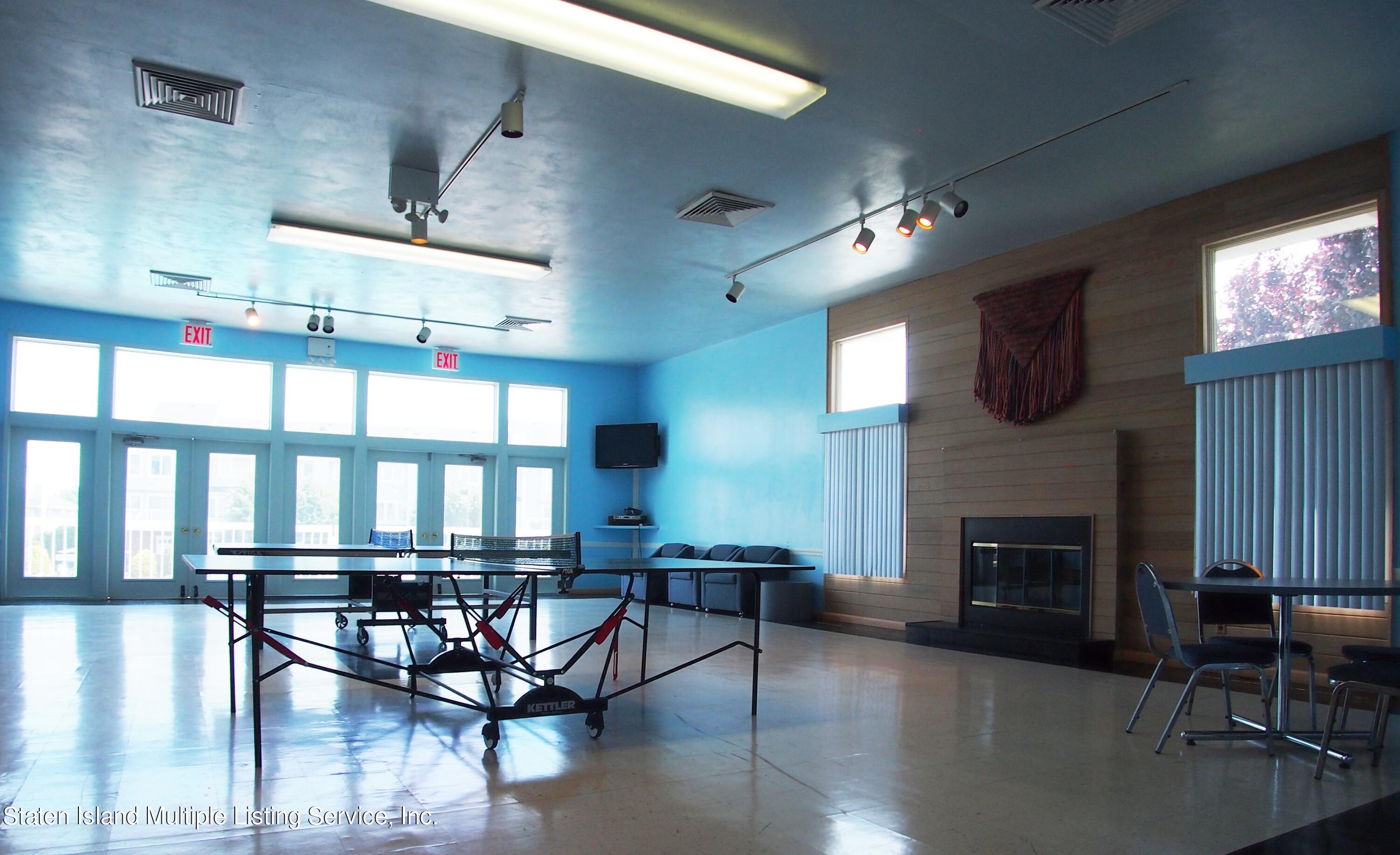 114 Commodore Drive Staten Island, NY 10309 - Photo 29 of 31 a living room with furniture a fireplace and a flat screen tv