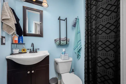 a bathroom with a sink a toilet a mirror and shower