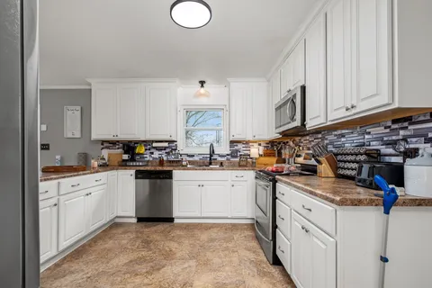 a kitchen with sink cabinets and a stove top oven