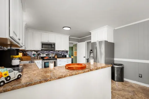 a kitchen with stainless steel appliances granite countertop a refrigerator stove microwave and sink