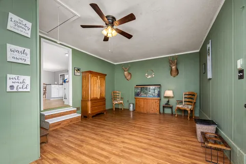 a view of a livingroom with furniture hardwood floor and a ceiling fan