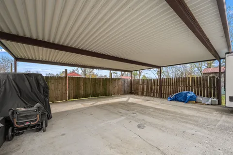 a balcony with wooden floor and large trees