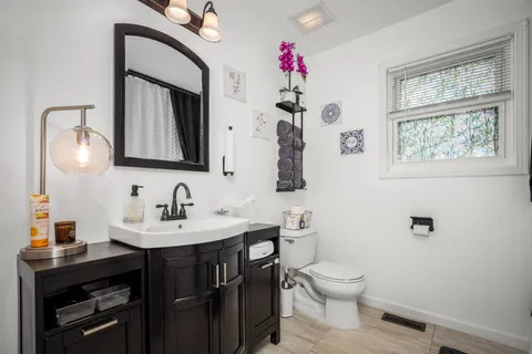 a bathroom with a toilet a sink and mirror