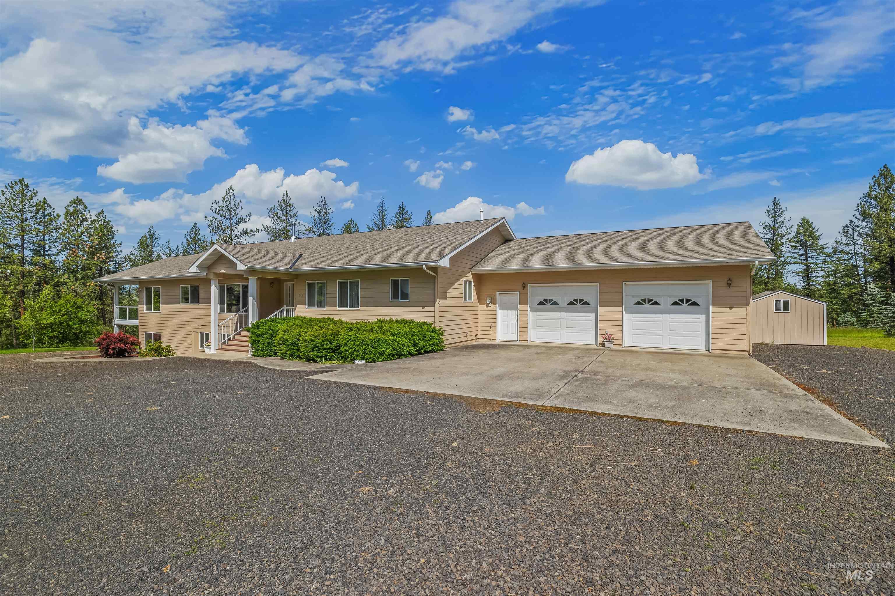743 Wall Crk Road Stites, ID 83552 - Photo 9 of 48 Ranch-style residence featuring a prominent covered entry, a two-car garage with arched window inserts, and an additional detached utility shed