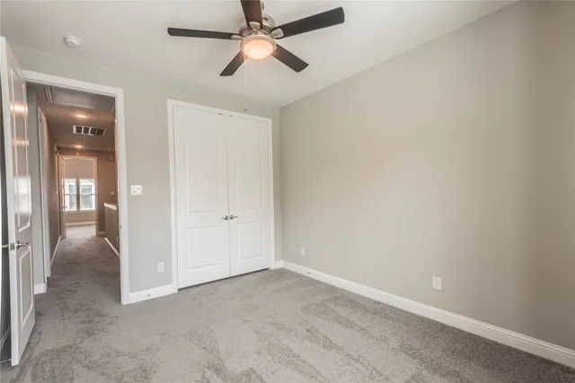 an empty room with fan and entrance