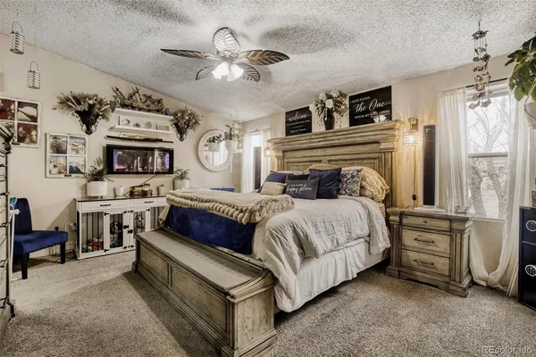 a bedroom with a bed a chandelier and a fireplace