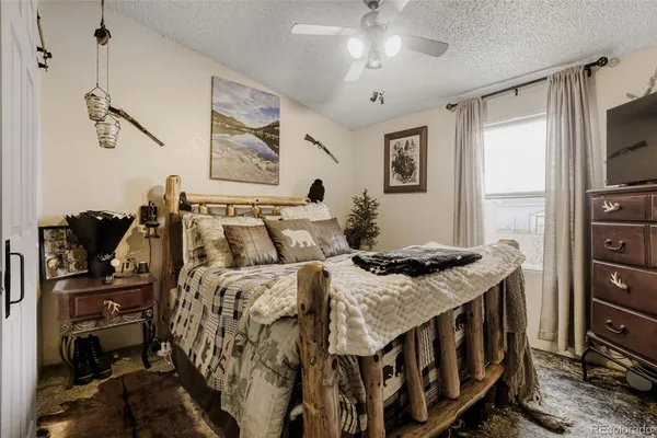 a bedroom with a bed and a flat tv screen on the dresser