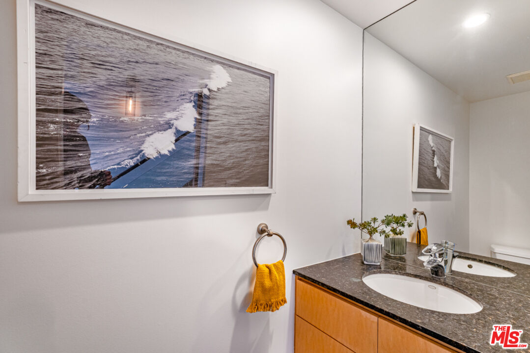 25 Brooks Avenue, Unit 3 Venice, CA 90291 - Photo 12 of 34 a bathroom with a granite countertop sink and a mirror