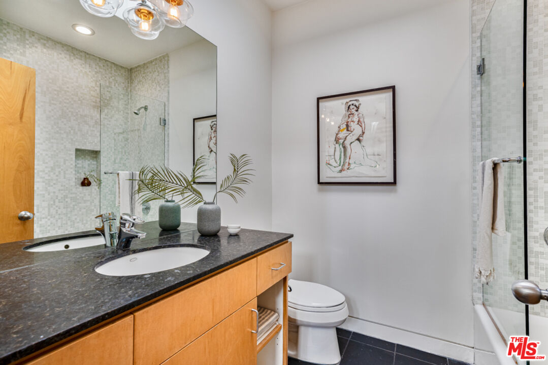 25 Brooks Avenue, Unit 3 Venice, CA 90291 - Photo 22 of 34 a bathroom with a granite countertop sink and a mirror with toilet