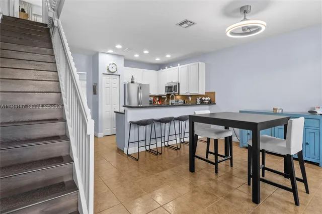 a view of a dining room kitchen with furniture and staircase
