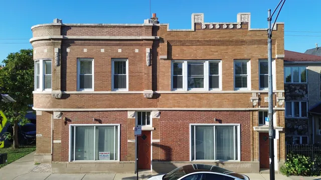 front view of a brick house with a small yard