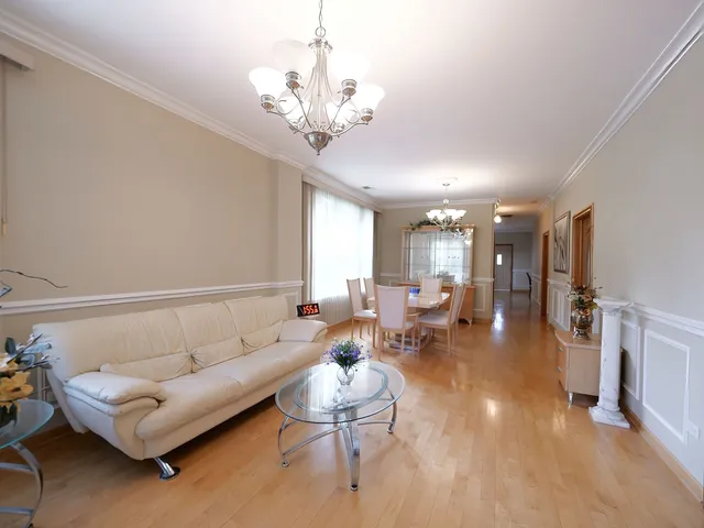 a bedroom with a bed chandelier and a window