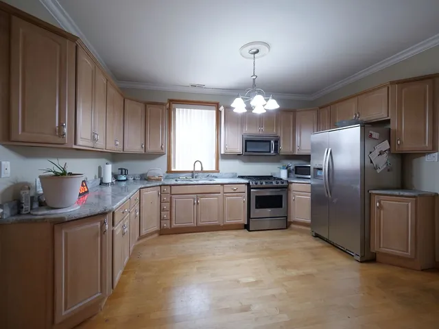 a view of a big room with wooden floor and windows