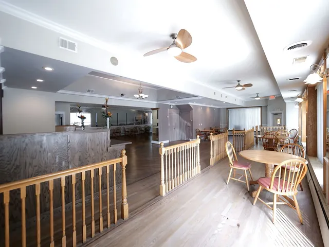 a very nice looking dining room with furniture a chandelier and wooden floor