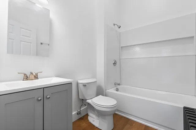 a bathroom with a toilet sink vanity tub and shower