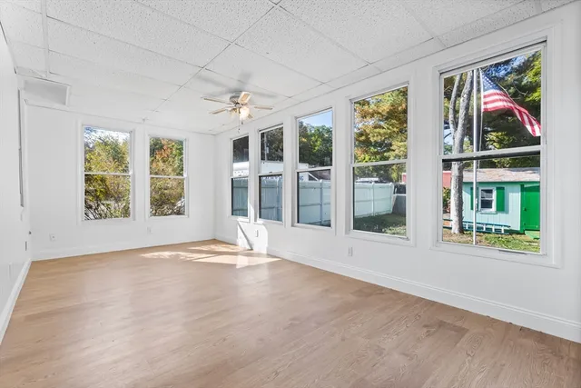 a view of an apartment with wooden floor and a window