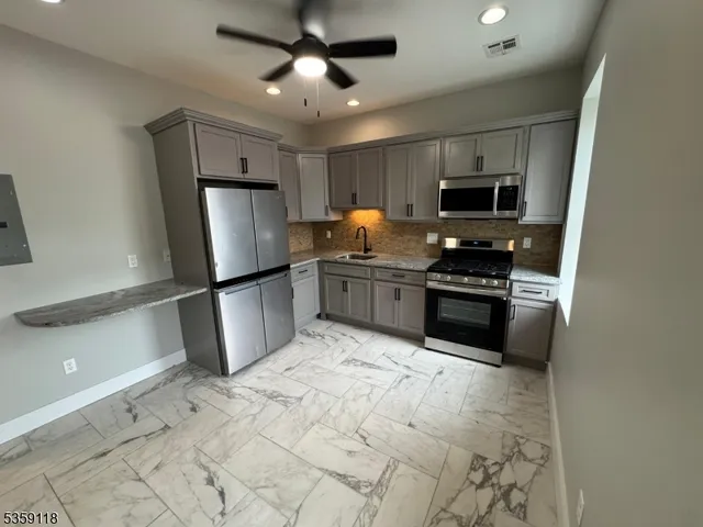 a kitchen with stainless steel appliances a refrigerator stove microwave and sink