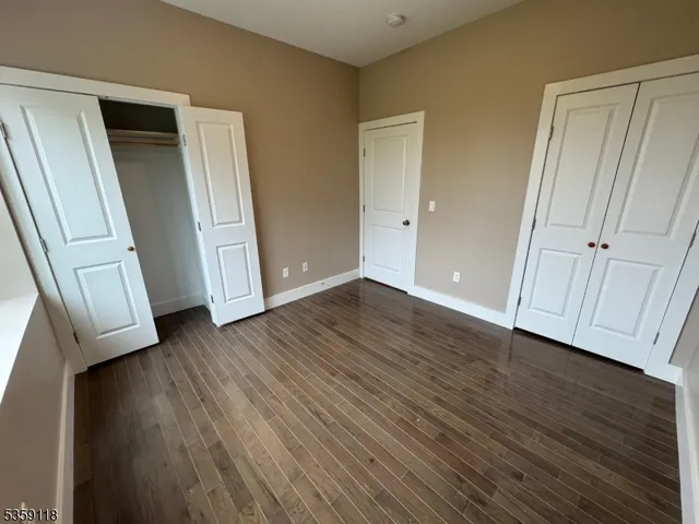 an empty room with wooden floor and stairs