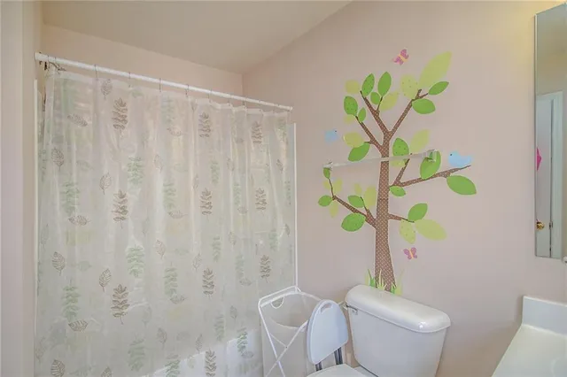 a white vase with a white flower and a chair