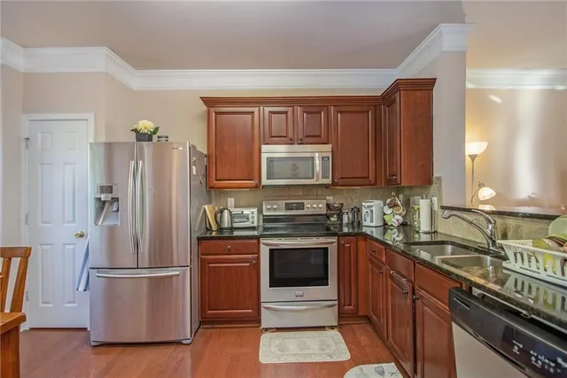 a kitchen with stainless steel appliances a refrigerator stove and sink