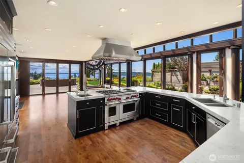 a kitchen with stainless steel appliances granite countertop a stove and a large window