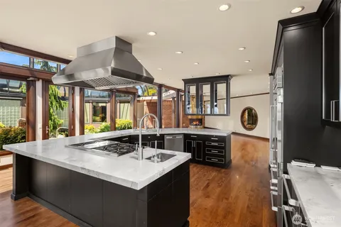 a kitchen with stainless steel appliances granite countertop a sink a stove and a refrigerator