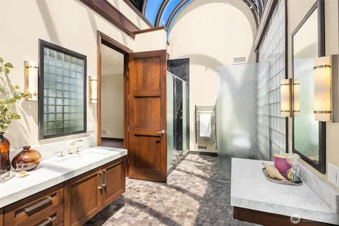 a bathroom with a sink mirror and a shower