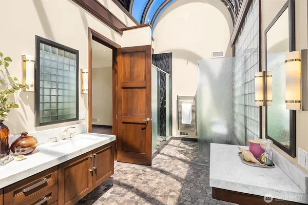 a bathroom with a sink mirror and a shower