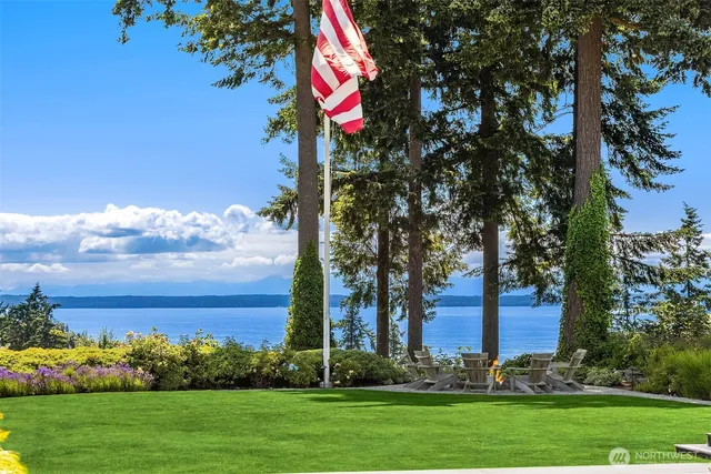 a front view of a house with a big yard and palm trees