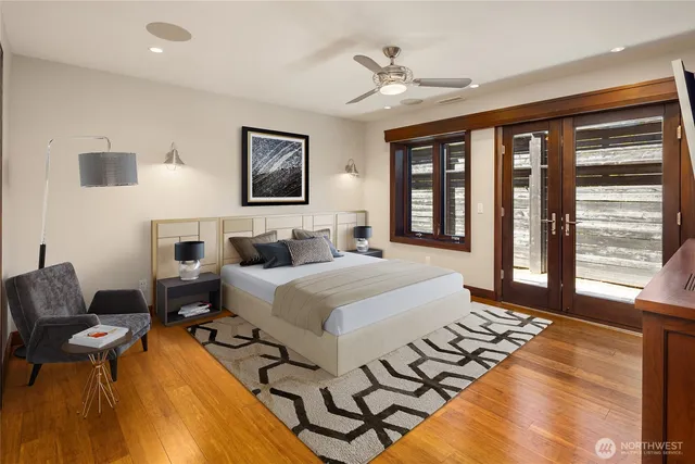 a spacious bedroom with a bed a couch and large window