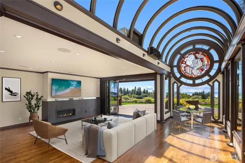 a living room with fireplace furniture and a large window